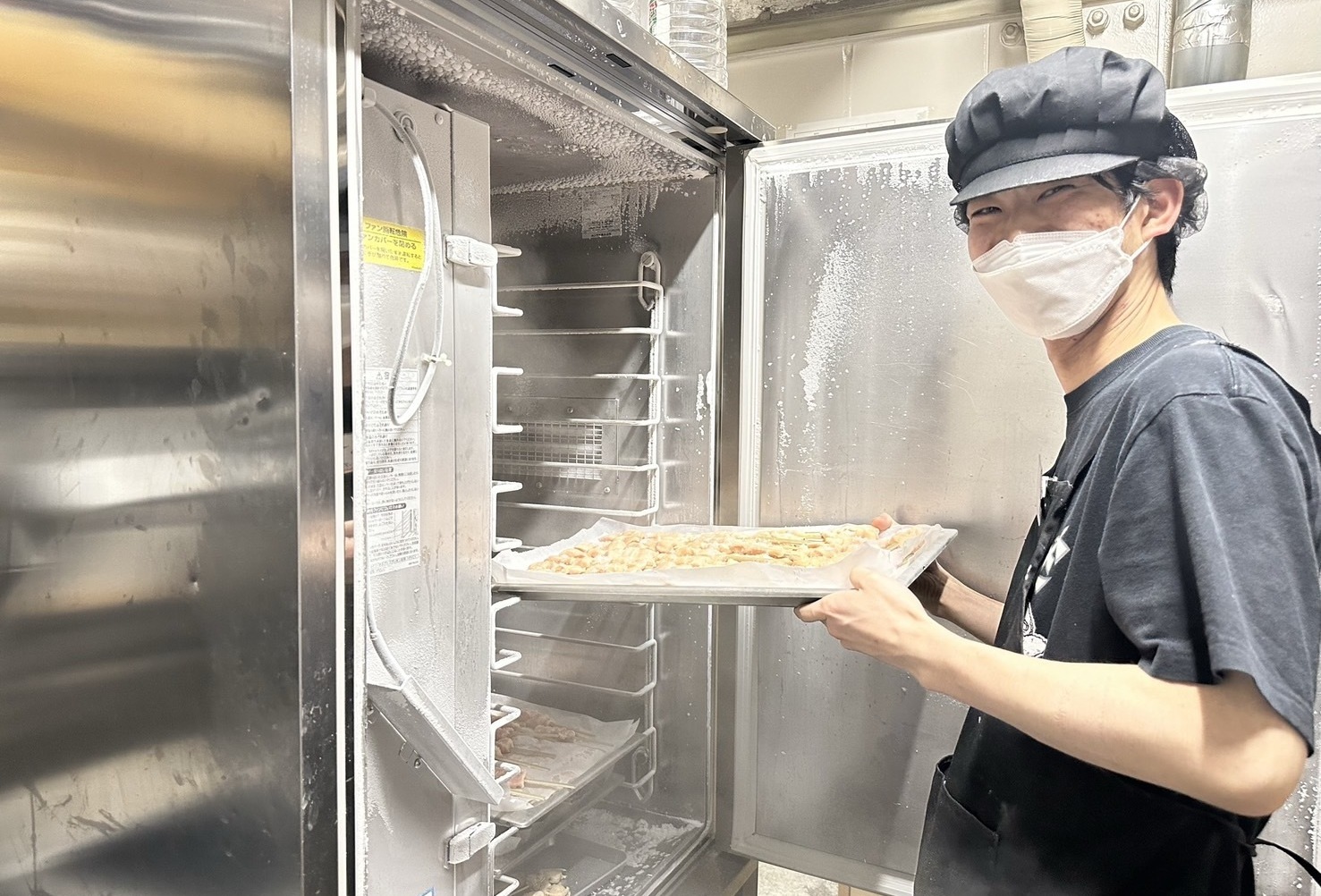 笑顔で調理をしている店員の写真