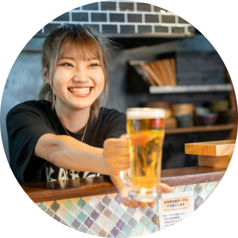 笑顔でビールを渡している店員の写真