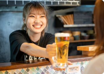 笑顔でビールを渡している店員の写真