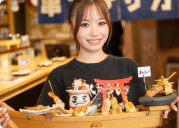 笑顔で舟盛りを抱えている店員の写真